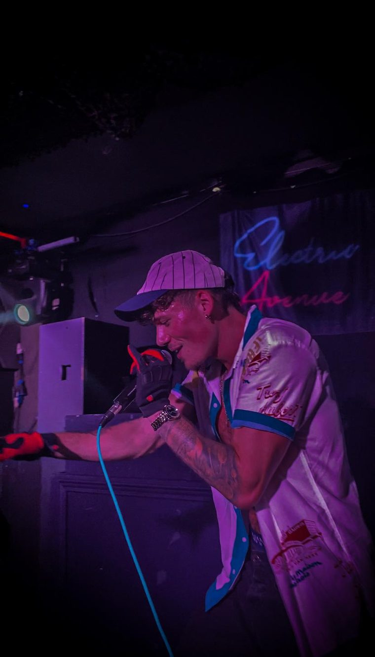 Flexx Carter performing under purple stage lights at Electric Avenue